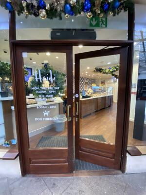 Brown framed glass door. Push gold metal handle from centre to open.