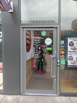 Glass door with grey frame ahead. Push from handle on right to open. Doorbell on right doorframe.