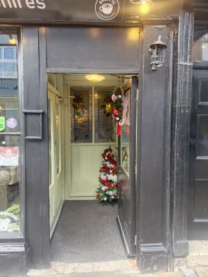 Glass door with black frame ahead. Push from handle on left to open.