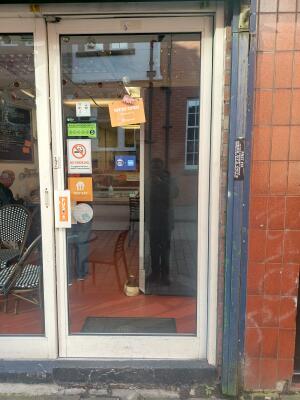 Glass door with white frame ahead. Push from handle on left to open.