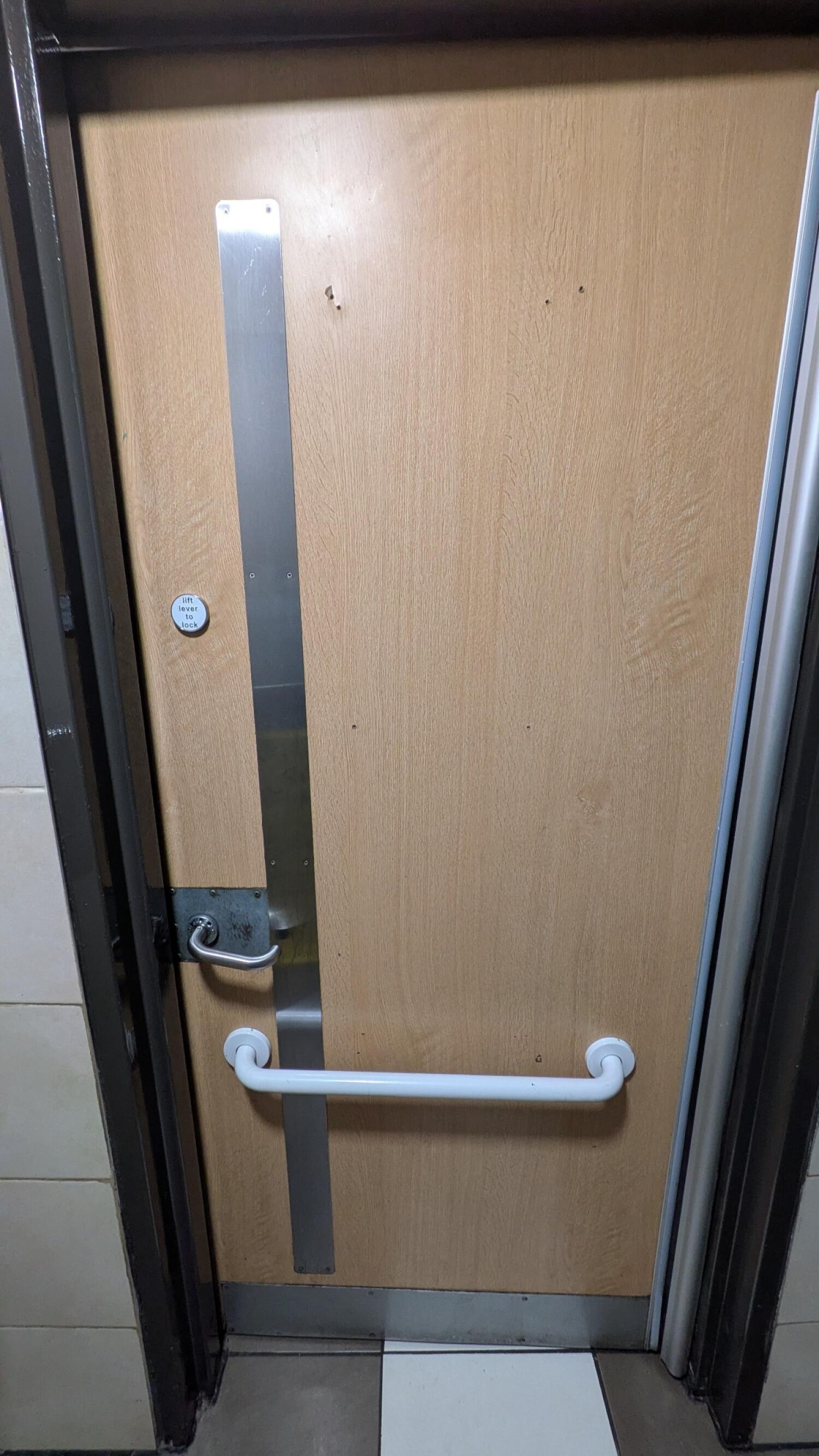 Back of second door. Lock on left. Pull from metal handle on left to open. Grab rail in centre.