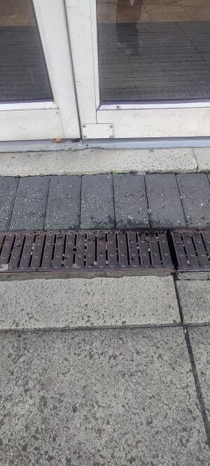 Slope up and metal grates before doorway.
