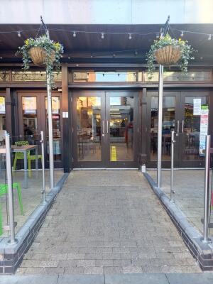 From street facing venue. Glass partitions on left and right. Pathway at centre.
