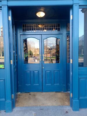 Glass panel blue door ahead. Push from handle at centre to open.