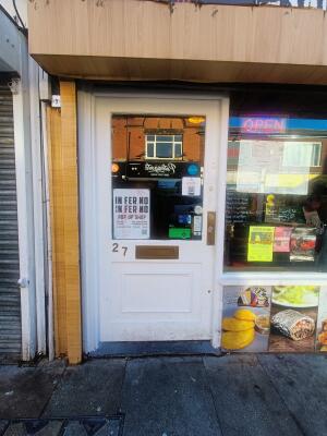 Glass panelled white door. Push handle on right to open.