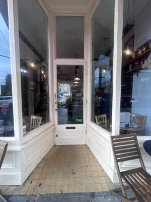 White wooden archway ahead. Door at back.