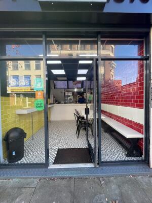 Glass door with grey frame. Pull from handle at centre to open.