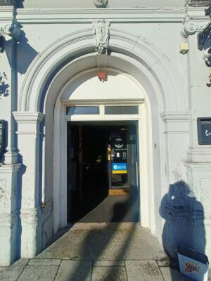 Black door with white frame. Push handle in centre to open.