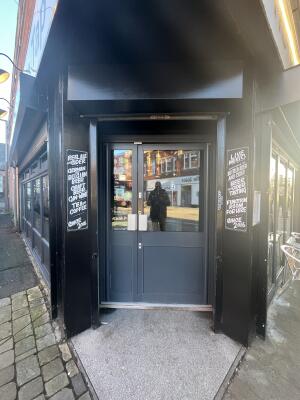 Glass panelled wooden door. Pull handle in centre to open.