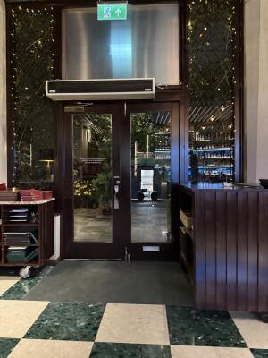 Dark wood-framed glass door. Push from handle on right to open.