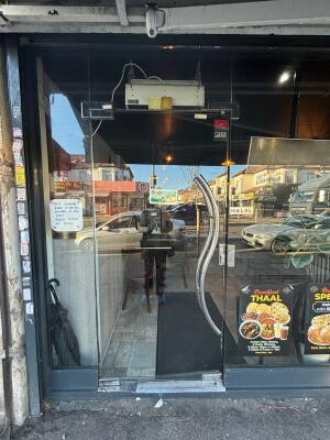 Glass door. Push silver metal handle from right to open.