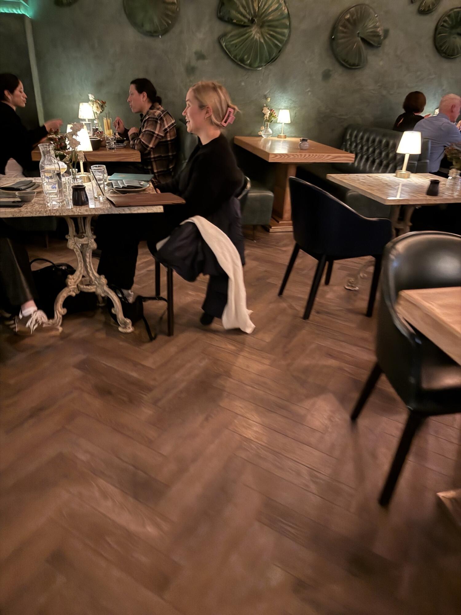 Tables and chairs along right. Path in centre. Booth seating along back wall.