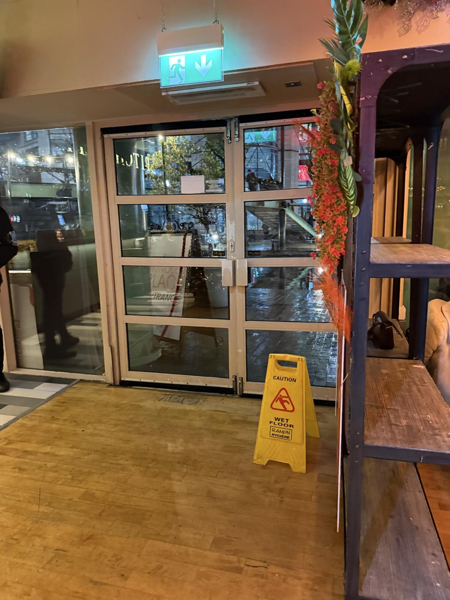 White metal-framed glass door. Push from handle on right to open.