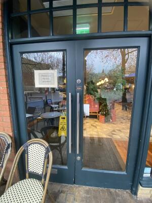 Blue framed glass door. Push silver metal handle from centre to open.