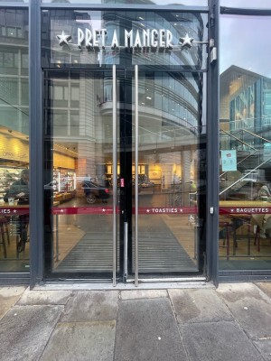 Glass doors with black framing ahead. Pull from metal handles in centre to open.