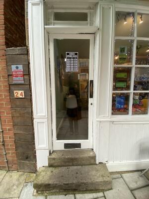 White framed glass door. Push gold metal handle from right to open.