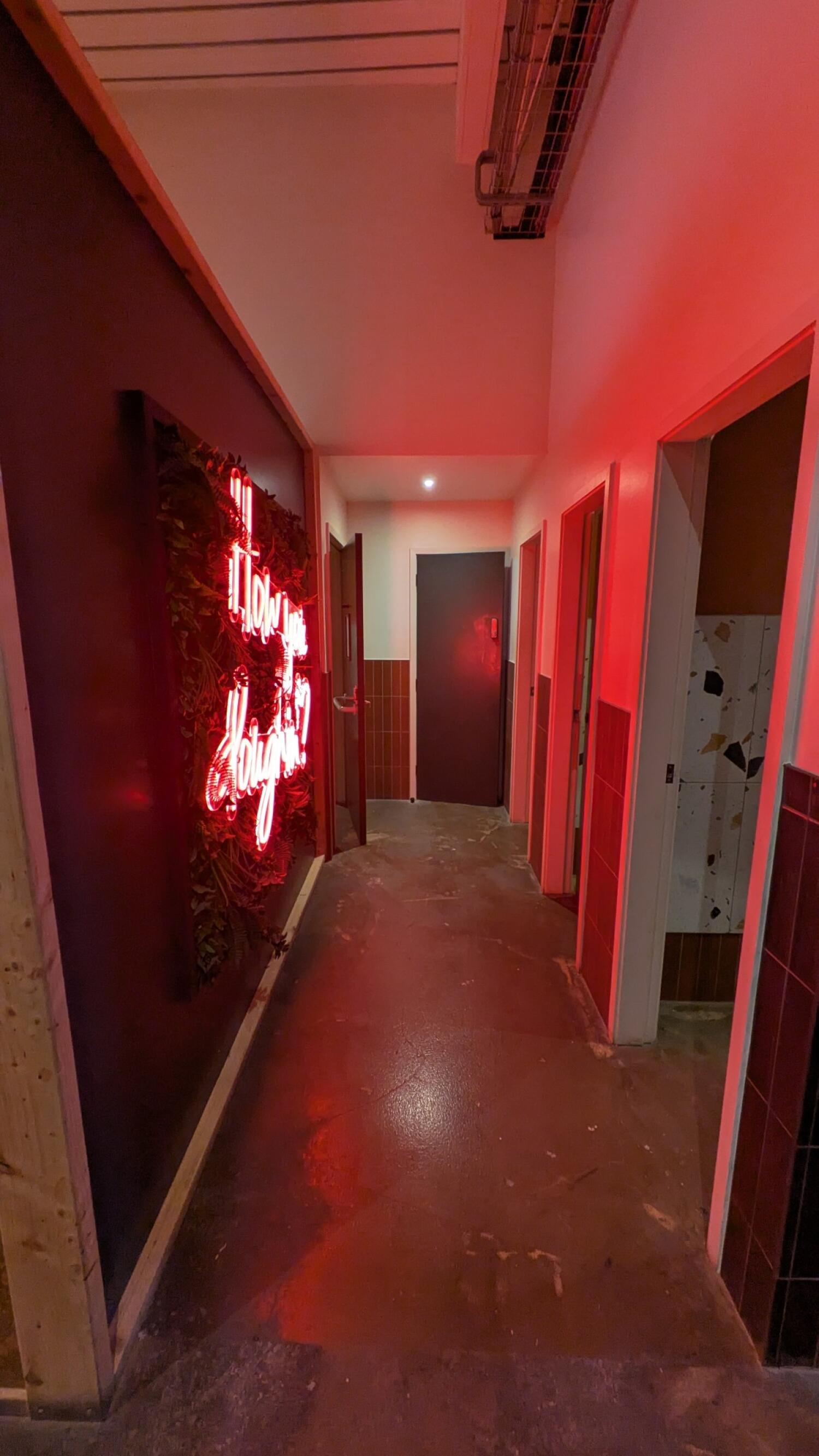 From path facing left. Door on left at end of path. Additional doors along right side.
