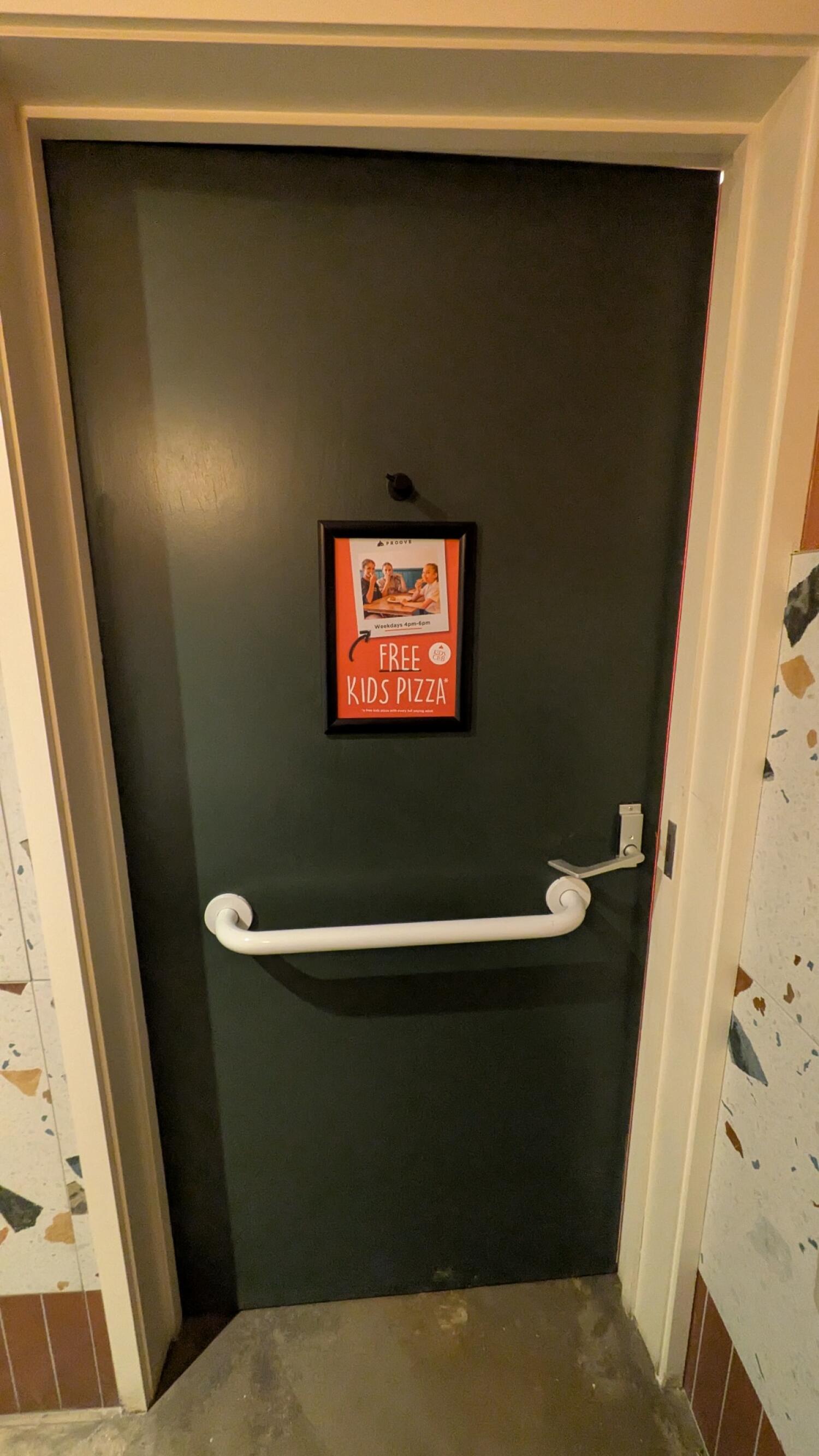 Back of door. Grab rail and high hanging hook in centre. Lock on right. Push from metal handle on right to open.