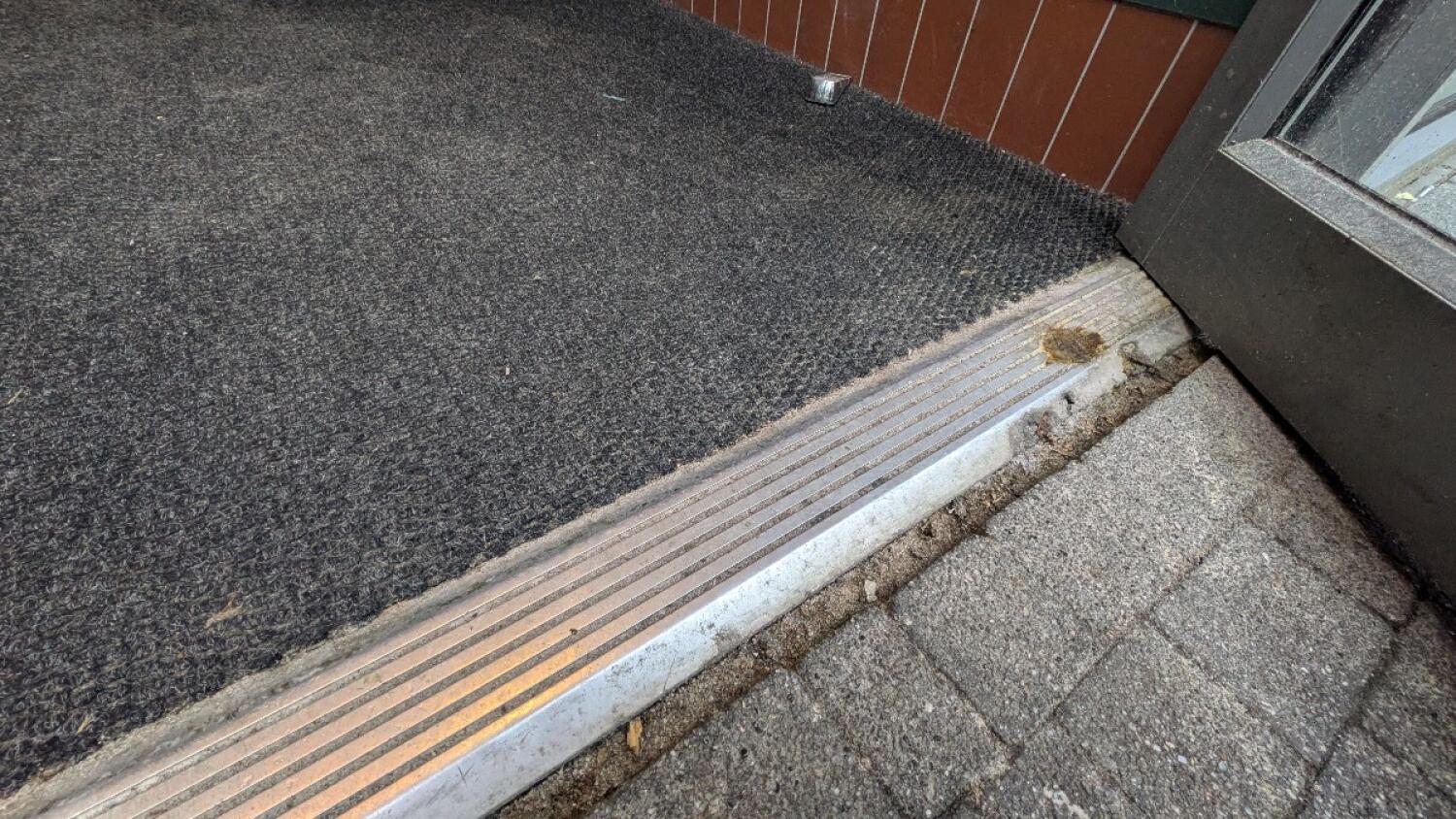 Small bump at foot of door. Doormat immediately after bump.