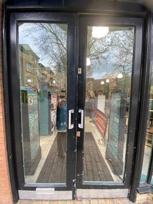 Black framed glass door. Push silver metal handle from centre open.