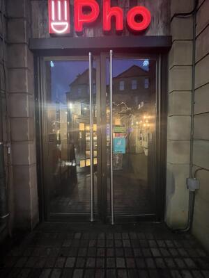 Glass doors with dark metal frame. Pull from handles at centre to open.