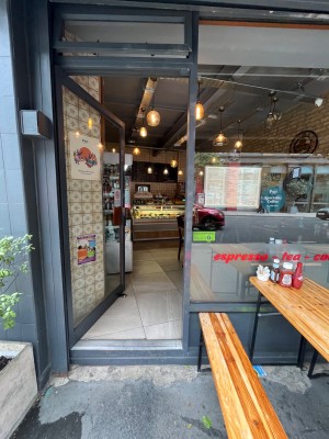 Single glass door in grey metal frame. Push red metal handle from right to open.
