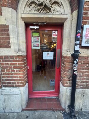Red framed glass door ahead. Push from right to open.