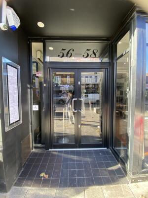 Black framed glass door. Pull silver metal handle from centre to open.
