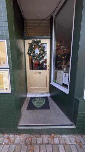 Gold wooden door with glass panel. Pull from handle on right to open.