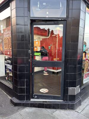 Black metal-framed glass door. Push from handle on left to open.