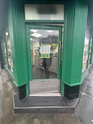 Green framed glass door ahead. Push handle on right to open.