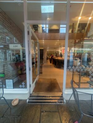 White frame glass door in front. Silver handle on right. Push to open.