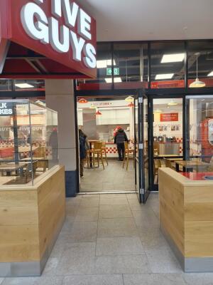 Opening ahead with barriers on left and right. Entrance door at back.