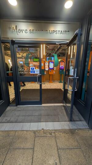 Dark metal-framed glass doors. Pull from metal handles at centre to open.