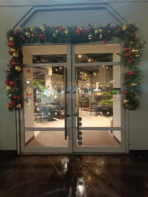 Glass doors with metal frame. Push from metal handles at centre to open.