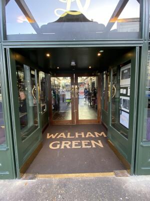 Green framed glass door. Push from centre to open.