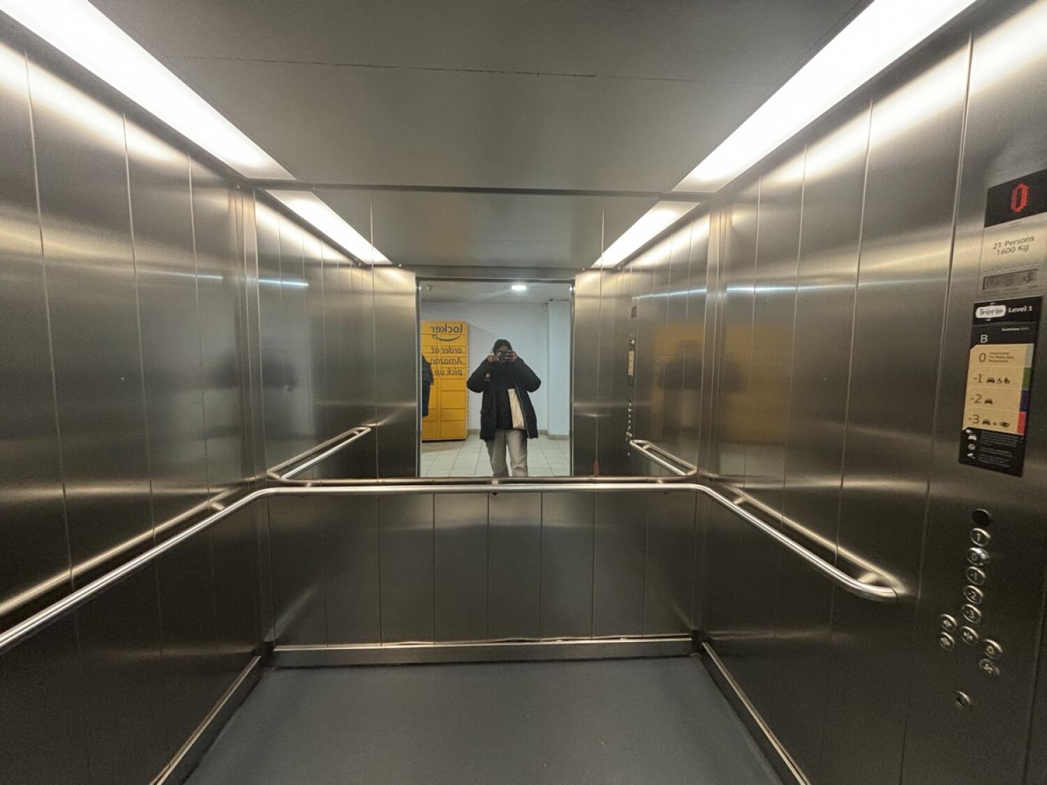 From lift door facing straight. Grab rails on left, right and back of lift.