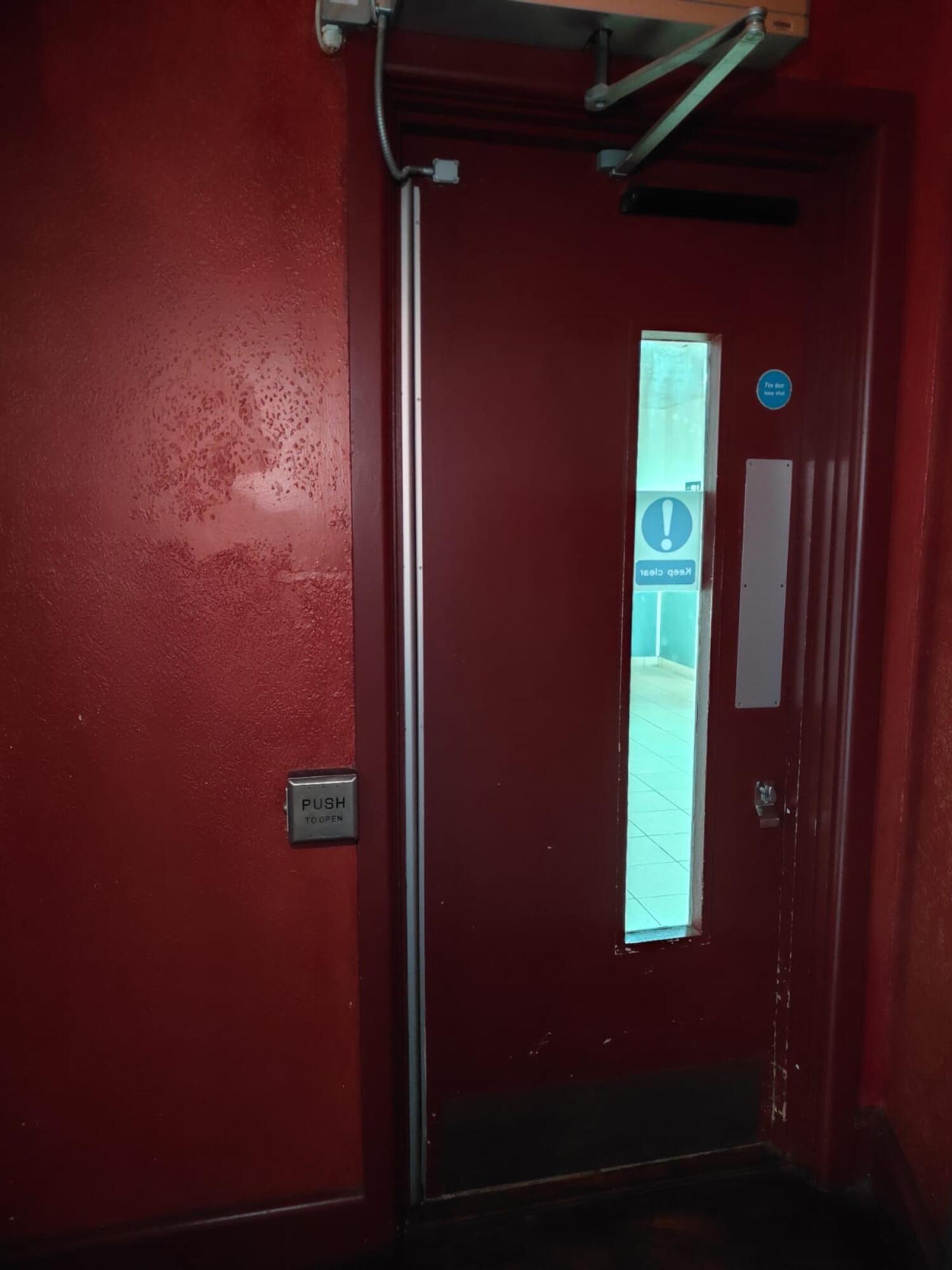 From end of path facing straight. Red glass panel door ahead. Push button on left of door to open.
