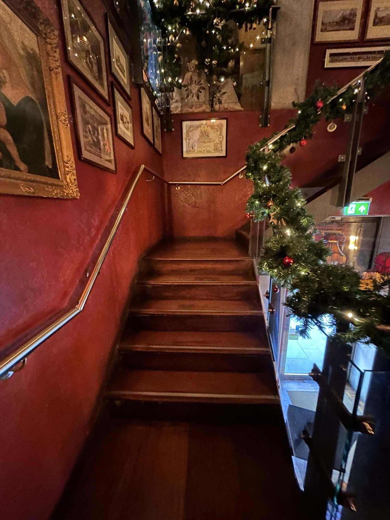 From landing facing right. Wooden stairs continue going up. Hand-rail on both sides.