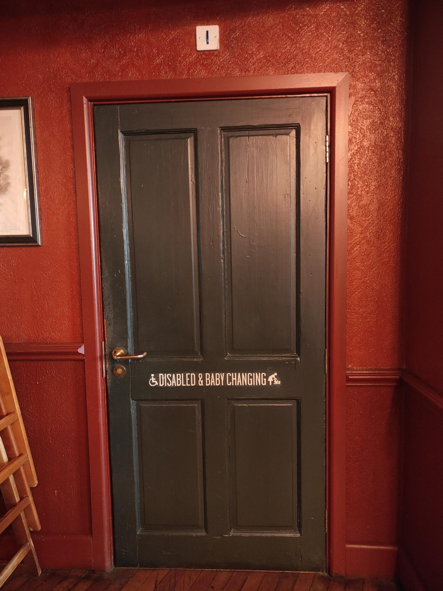 From right end of bar counter facing right. Black toilet door ahead. Pull golden handle on left to open.