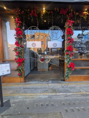 Wooden frame glass doors in front. Gold metal handle in center. Push to open.