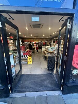 Black framed glass doors ahead. Push doors from centre to open.