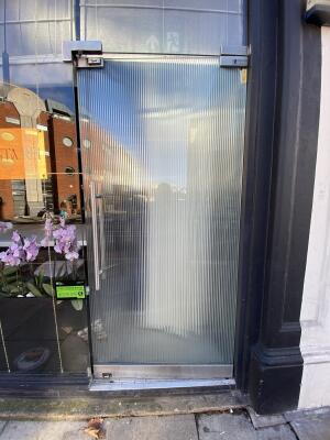 Frosted glass door. Push silver metal handle from left to open.