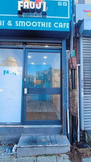Black framed glass door to venue. Push handle on left to open.