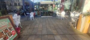 From street facing venue. Open entrance. Fencing on both sides. Door at back center.