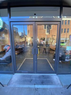 Grey framed glass door. Pull grey metal handle from centre to open.