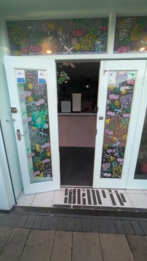 White-framed glass doors. Pull from handle on left to open.