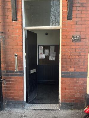 Black wooden double door. Push from handle in centre to open.