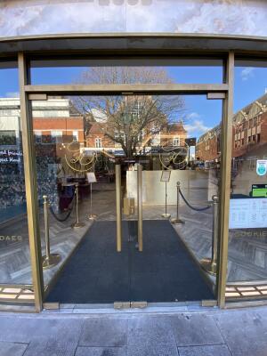 Gold framed glass door. Push gold metal handle from centre to open.