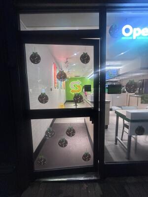 Glass door with black metal frames ahead. Push from right to open.